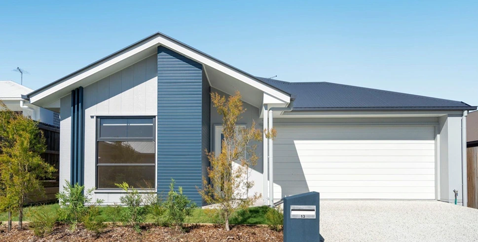 Modern facade with double garage and landscaped front yard.