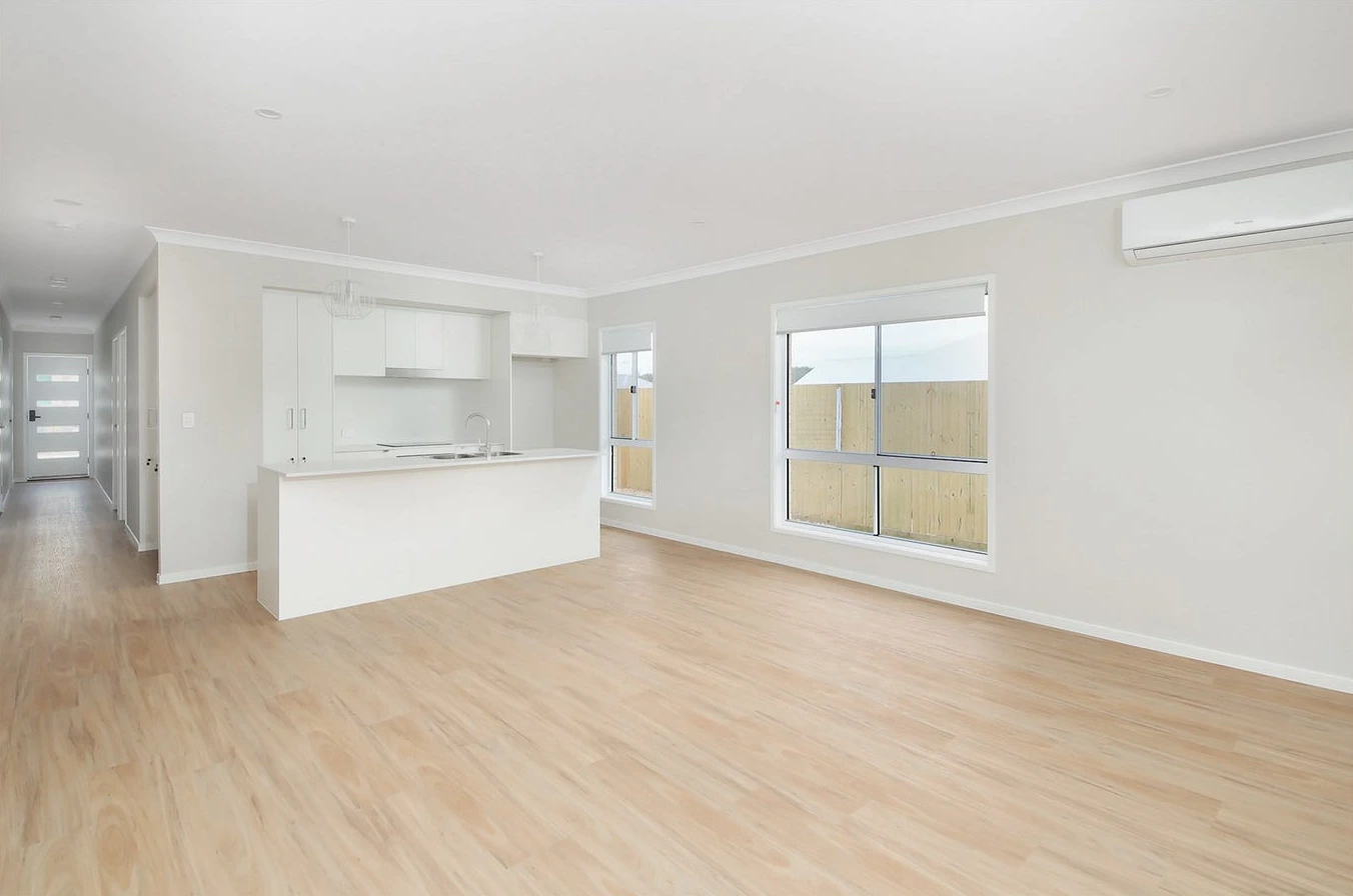 Spacious living area in 8 Lilly Lane home in Logan with timber flooring and large windows.