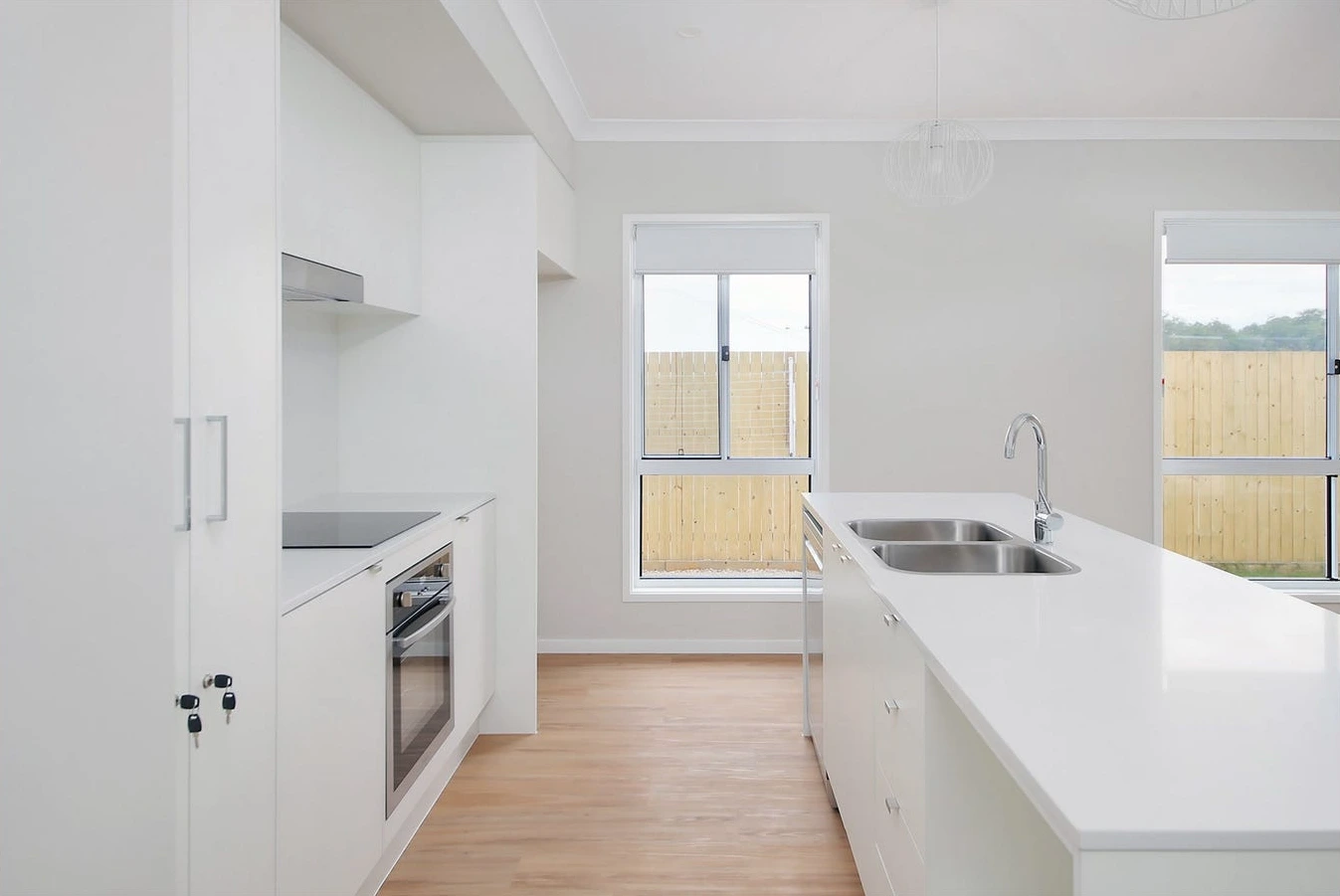 Modern kitchen in 8 Lilly Lane home in Logan with electric cooktop and sliding door access.