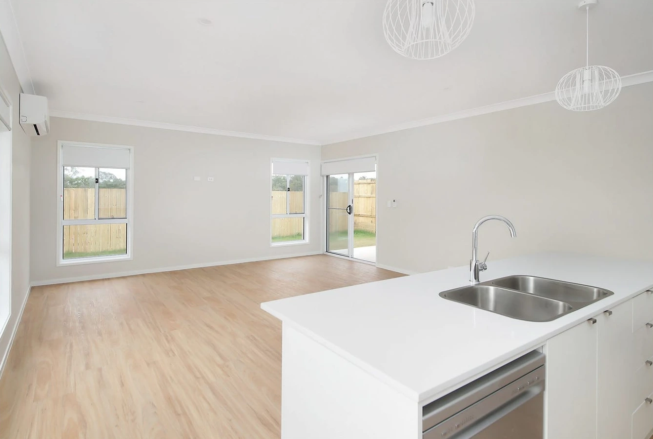Combined living and dining area in 8 Lilly Lane, Logan home with natural light and air conditioning.