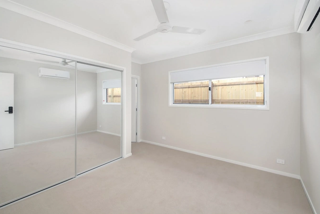 Additional bedroom in Logan home at 8 Lilly Lane with neutral tones and ceiling fan.