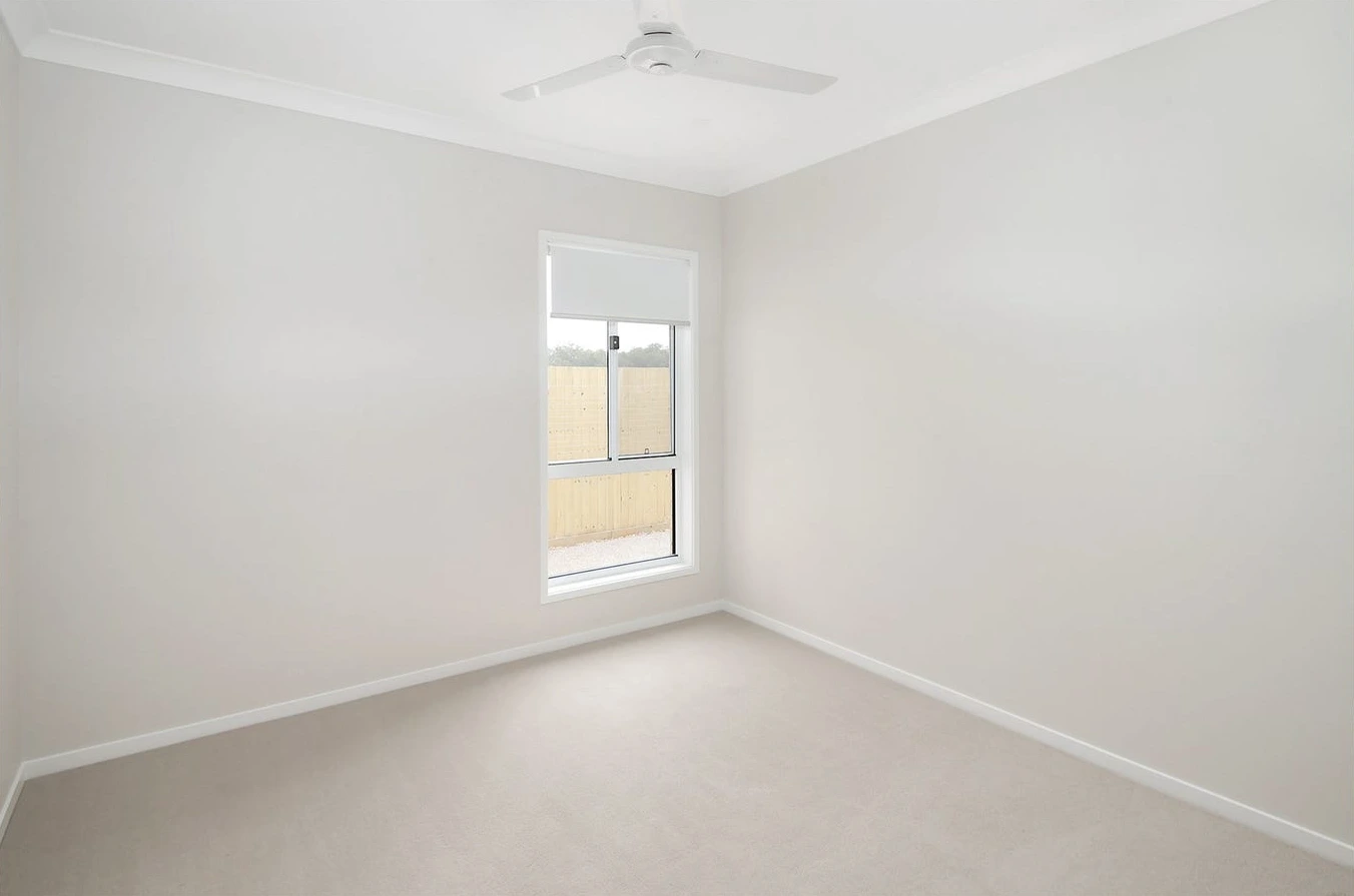 Third bedroom in 8 Lilly Lane home in Logan with soft flooring and large window.