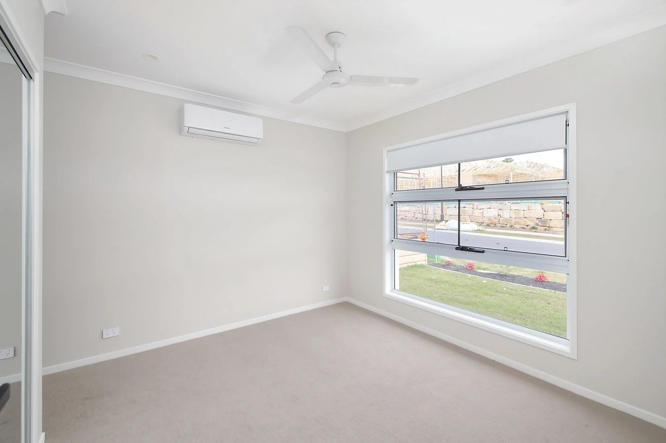 Air-conditioned room in 8 Lilly Lane home in Logan with wide window and ceiling fan.