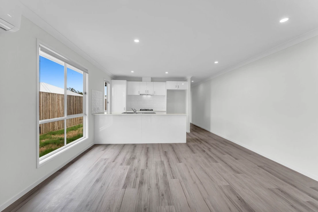 Living area in Brassall duplex at 1/7 Loch Way with timber floors and large window.