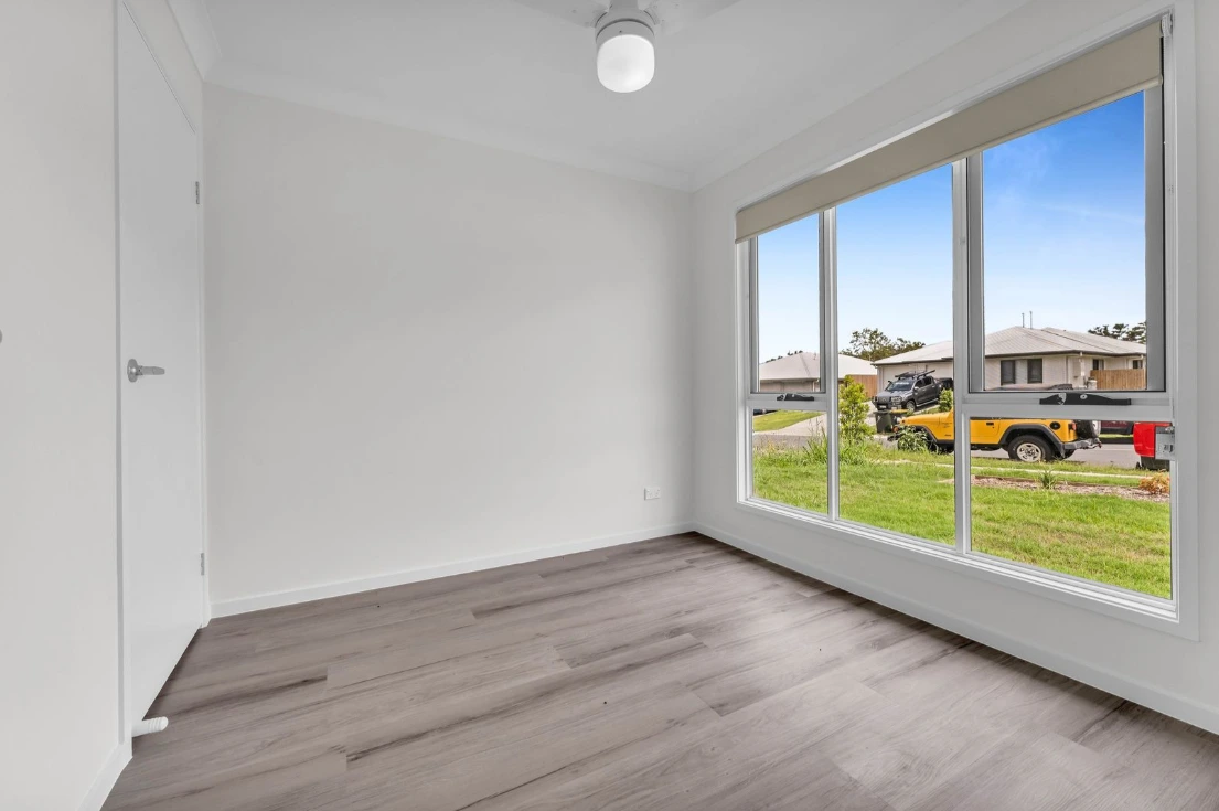 Sunlit room in duplex at 1/7 Loch Way, Brassall with large window and timber-style flooring.