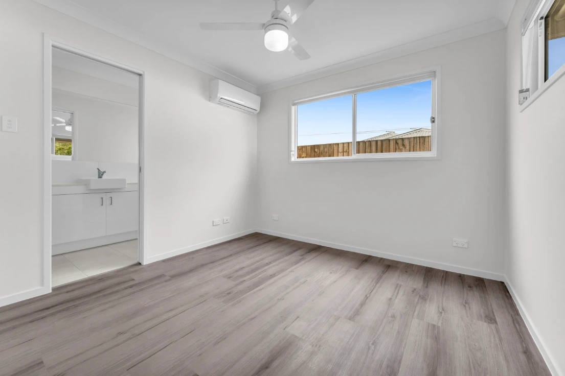 Spacious bedroom in 1/7 Loch Way duplex in Brassall featuring timber floors and natural light.
