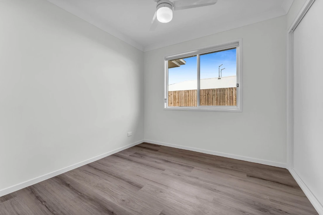 Bright bedroom in Brassall duplex at 1/7 Loch Way with modern flooring and garden views.