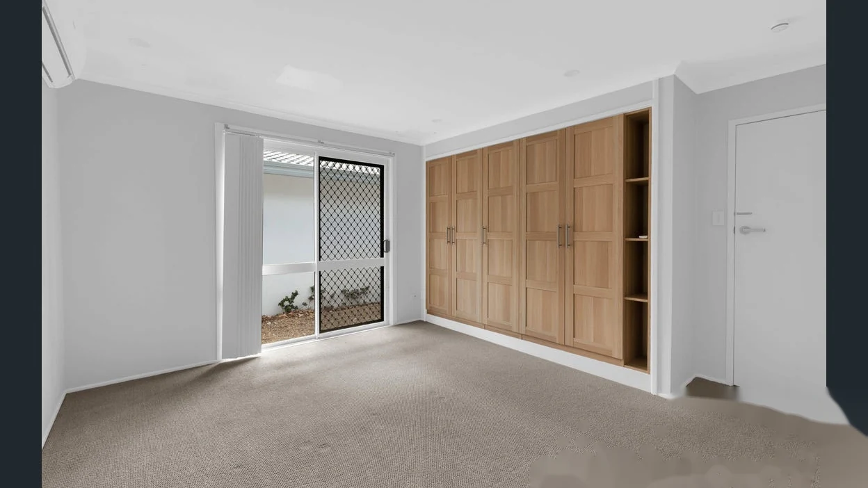 Spacious bedroom with built-in timber wardrobe at 2 Bejimba Street Kenmore by YMC