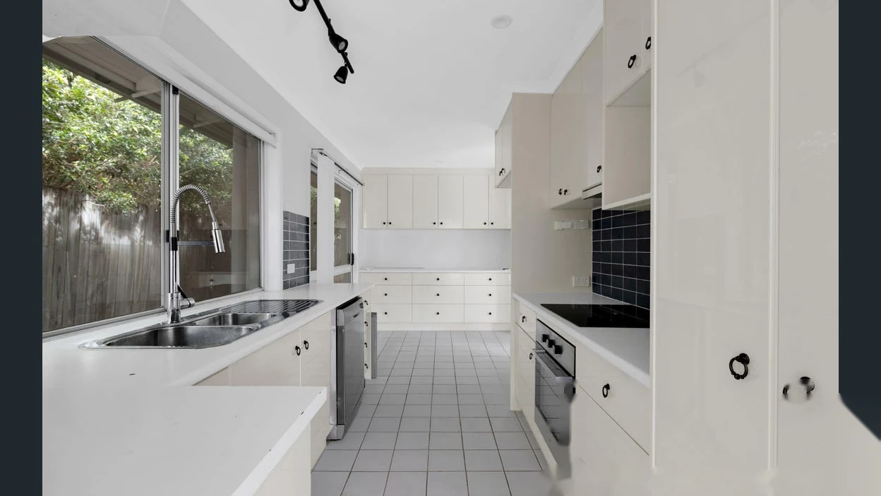 Modern white kitchen with ample cabinetry at 2 Bejimba Street Kenmore by YMC
