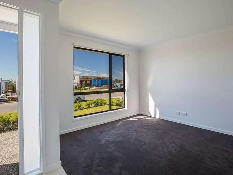 Front carpeted bedroom with street-facing window at 55 Hill Drive Pimpama property