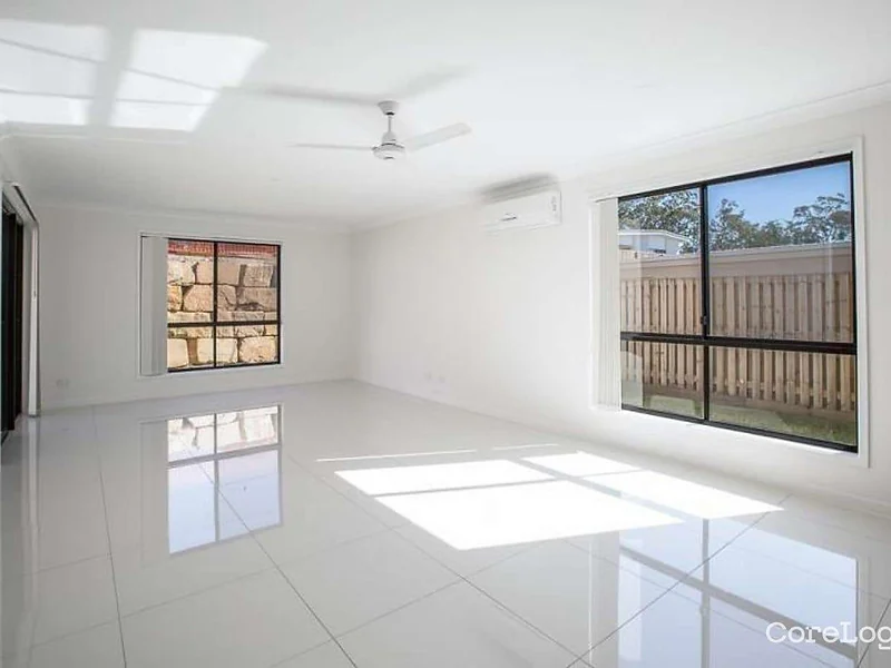 Open tiled living room with large windows at 55 Hill Drive Pimpama property