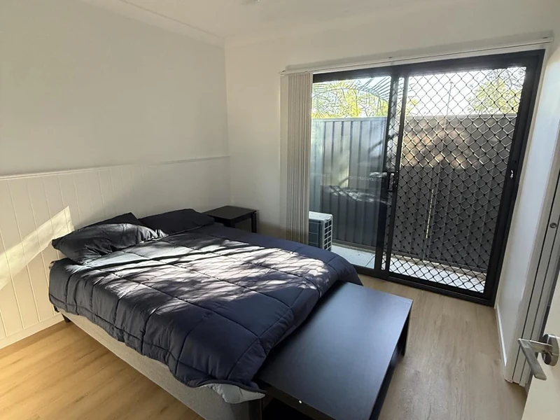 Bedroom with bed and sliding door access at 89 Marshall Road Rocklea accommodation