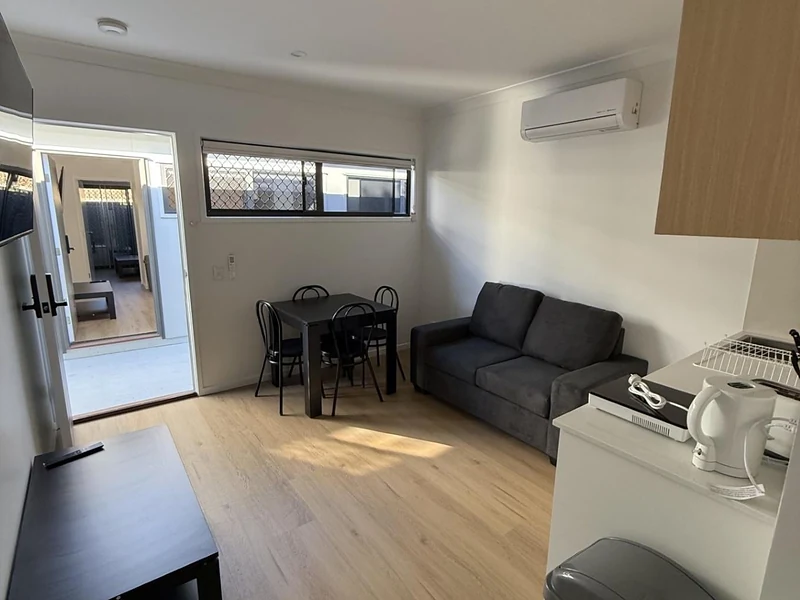 Open living area with sofa dining table and kitchenette at 89 Marshall Road Rocklea