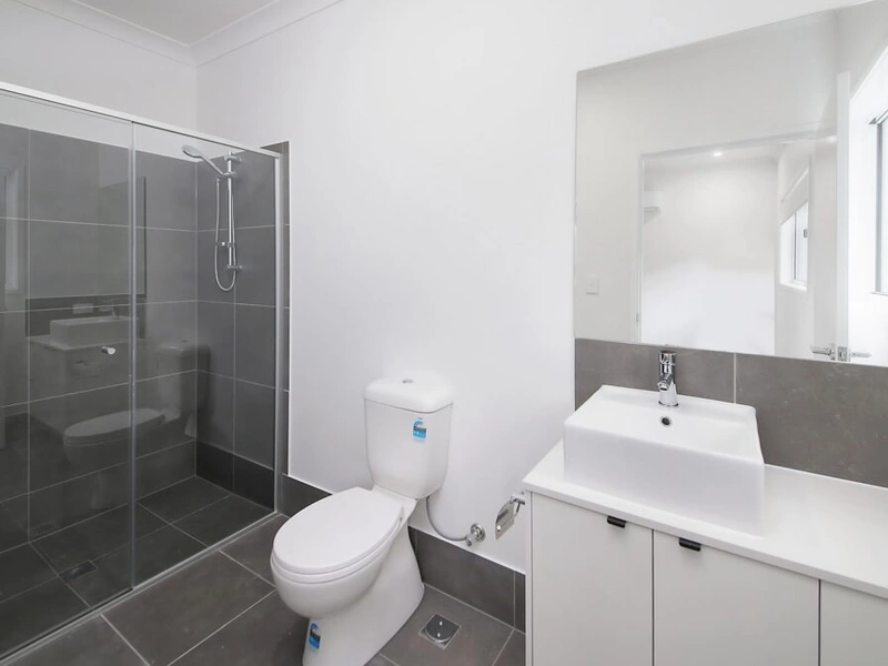 Modern bathroom with glass shower, toilet and vanity at Logan Reserve QLD 4133 property.