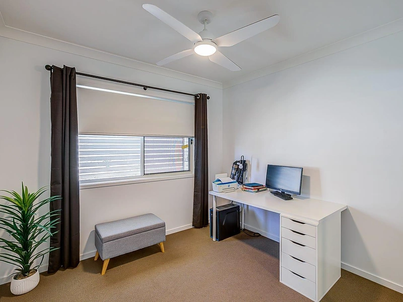 Bedroom with window, ceiling fan and desk area in Greenbank