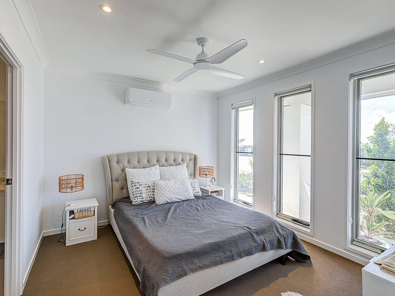 Bedroom with large windows, ceiling fan and natural light in Greenbank