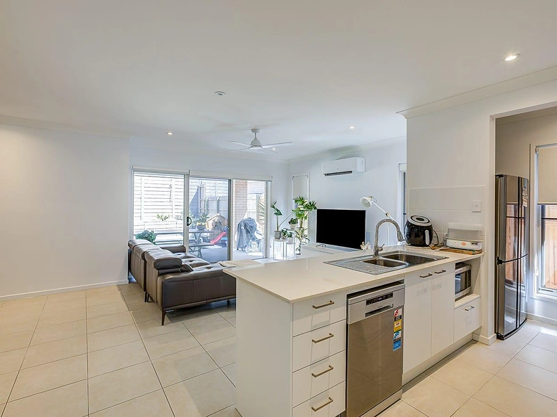 Open kitchen and living area with island bench in Greenbank