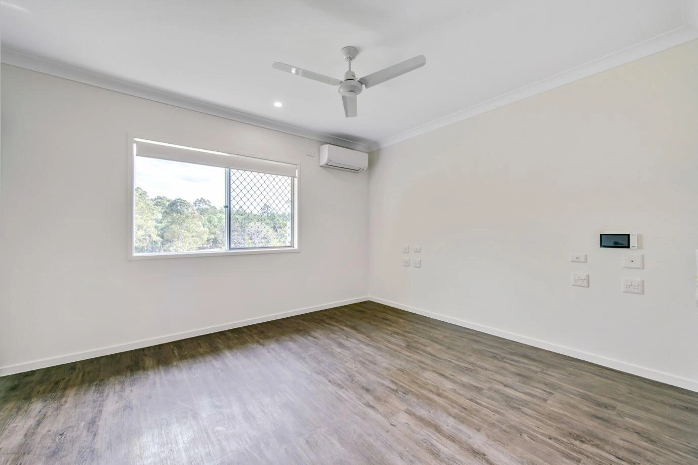 Bright accessible bedroom with ceiling fan and air conditioning in Ormeau