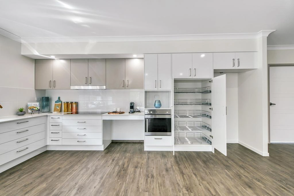 Spacious kitchen with built-in storage cabinetry and accessible layout in Ormeau
