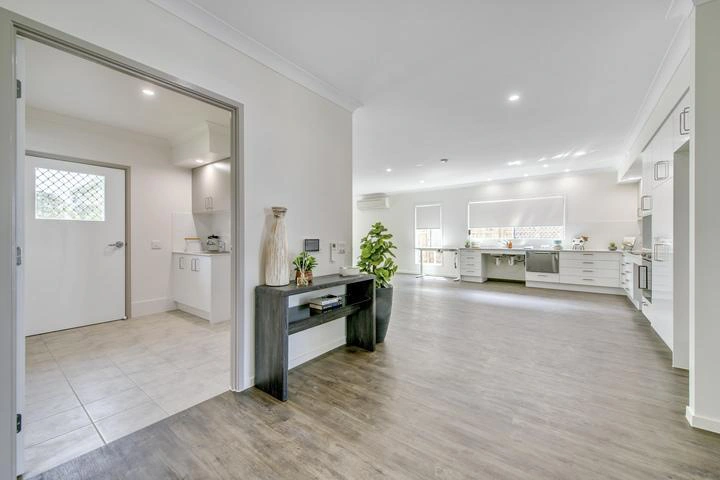 Open-plan kitchen and living area with wide accessible spaces in Ormeau